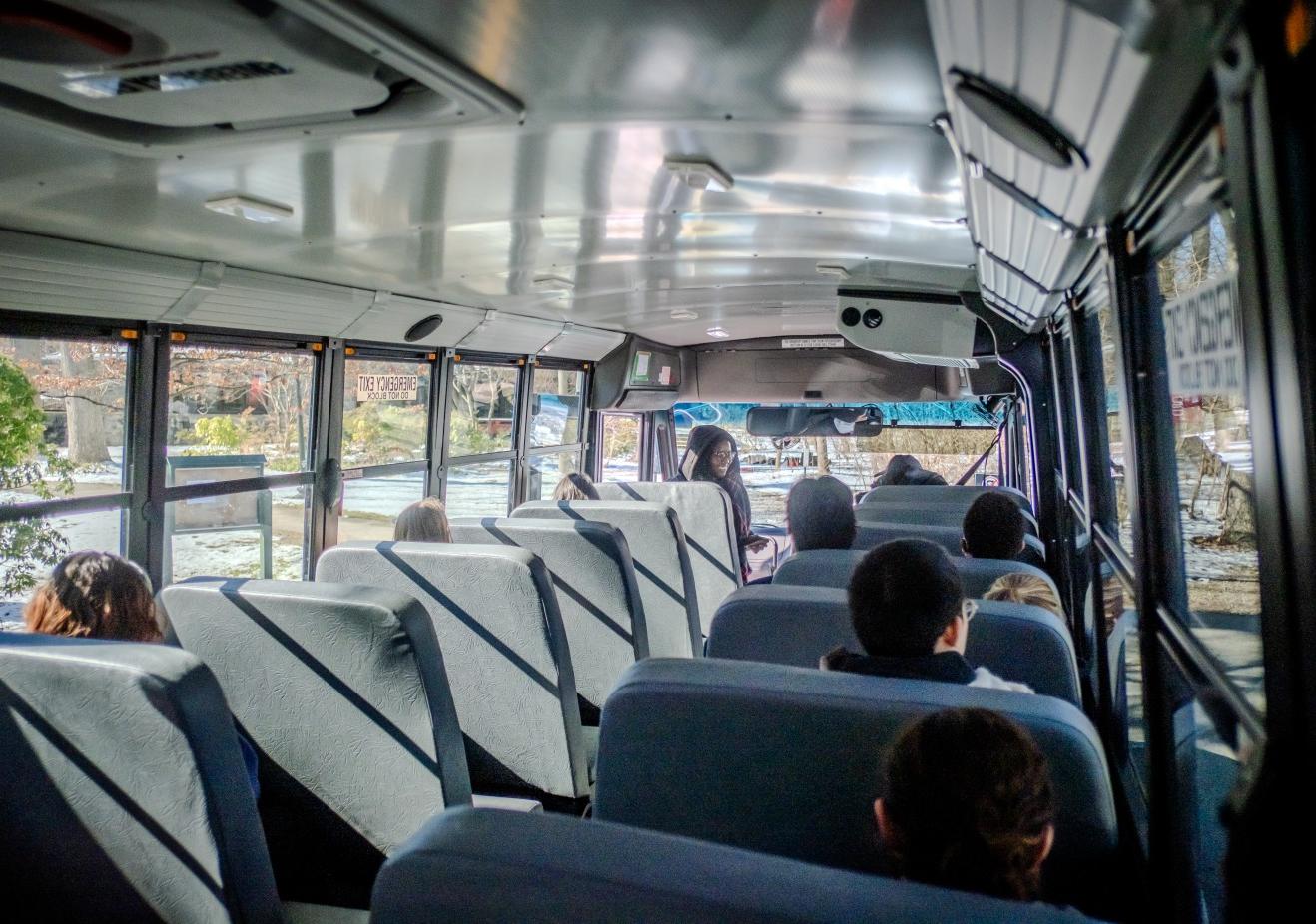 Students board the electric bus.